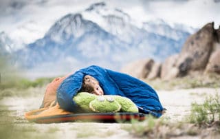 Sleeping in a sleeping bag while camping.