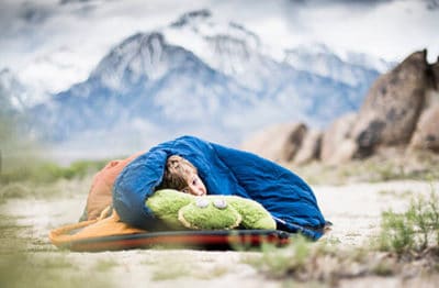 Sleeping in a sleeping bag while camping.