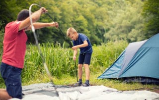 A father and son setting up a family camping tent.