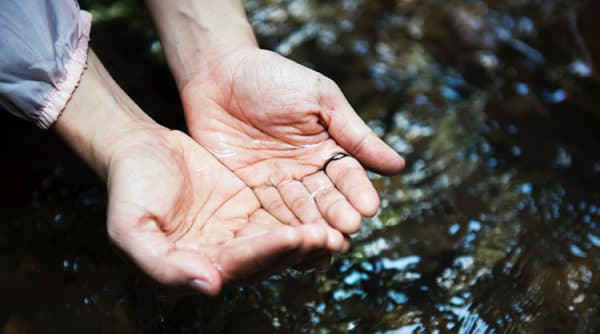 Cleaning hands in the river. Tips for keeping yourself and your kids clean while camping.